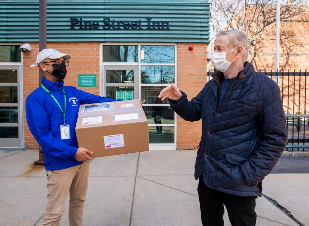 Andre Sharon (right), director of the Fraunhofer USA Center for Manufacturing Innovation at BU chats with Matt Ferrer, volunteer coordinator at The Pine Street Inn, after handing over a box of 1,000 masks on March 19. Photo by Cydney Scott for Boston University Photography